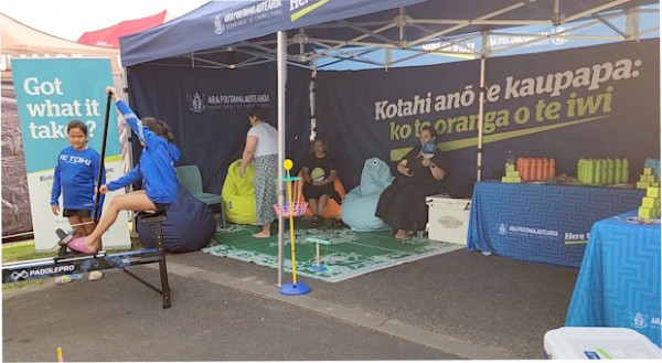 Children try out the erg pro machine outside a Corrections branded marquee